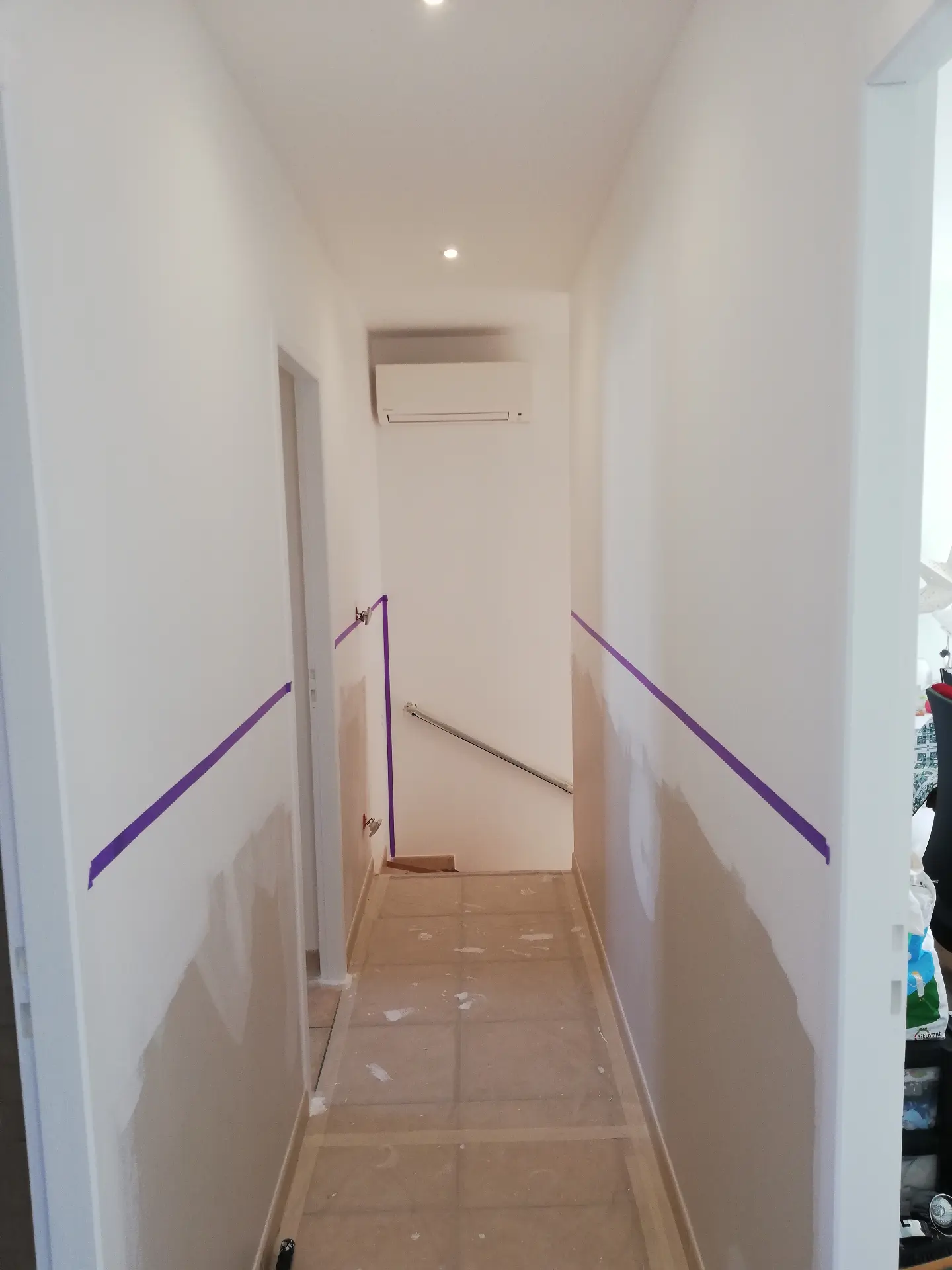 Couloir avant peinture - murs en préparation avec scotch de protection